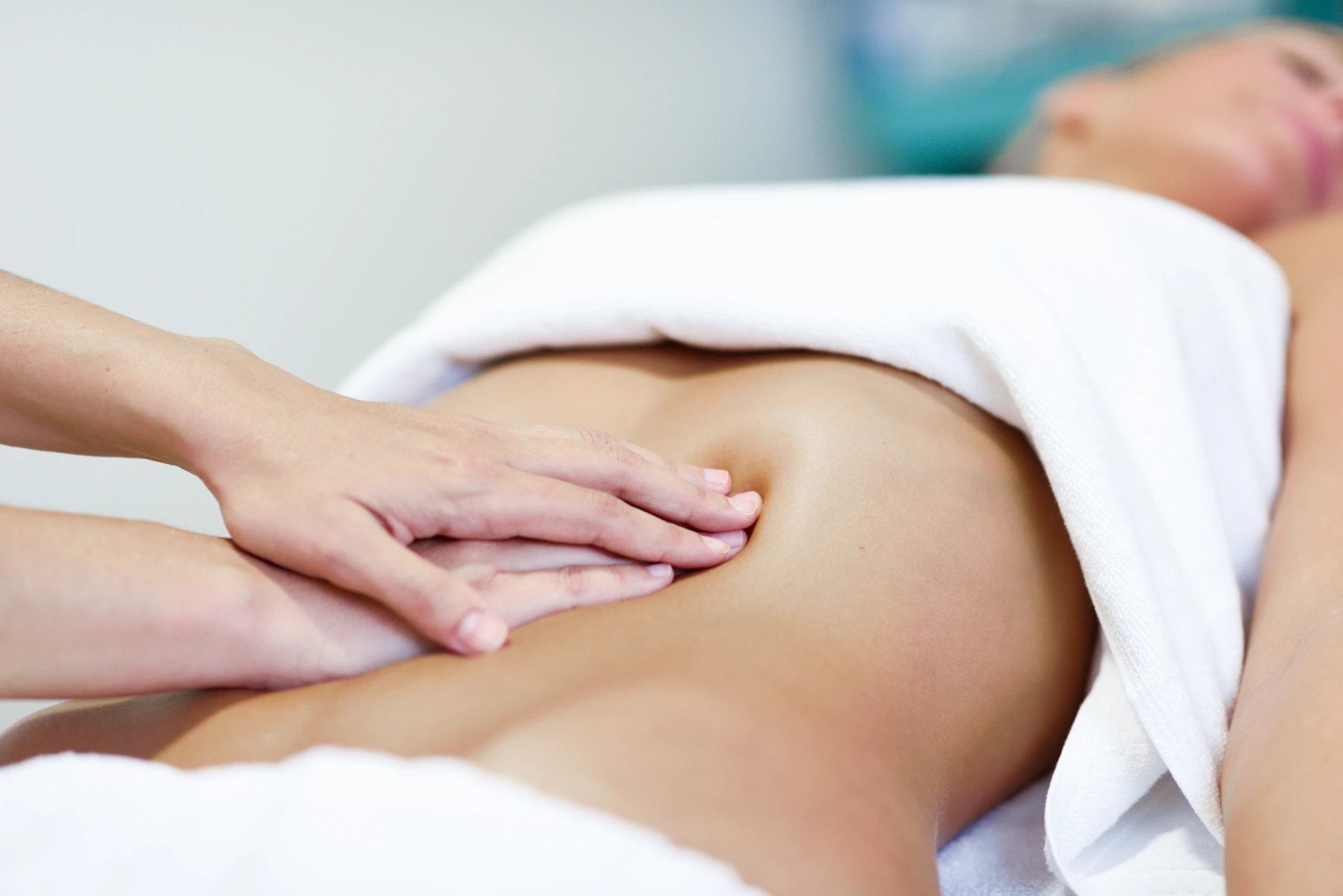 Therapist performing lymphatic massage on lower back.